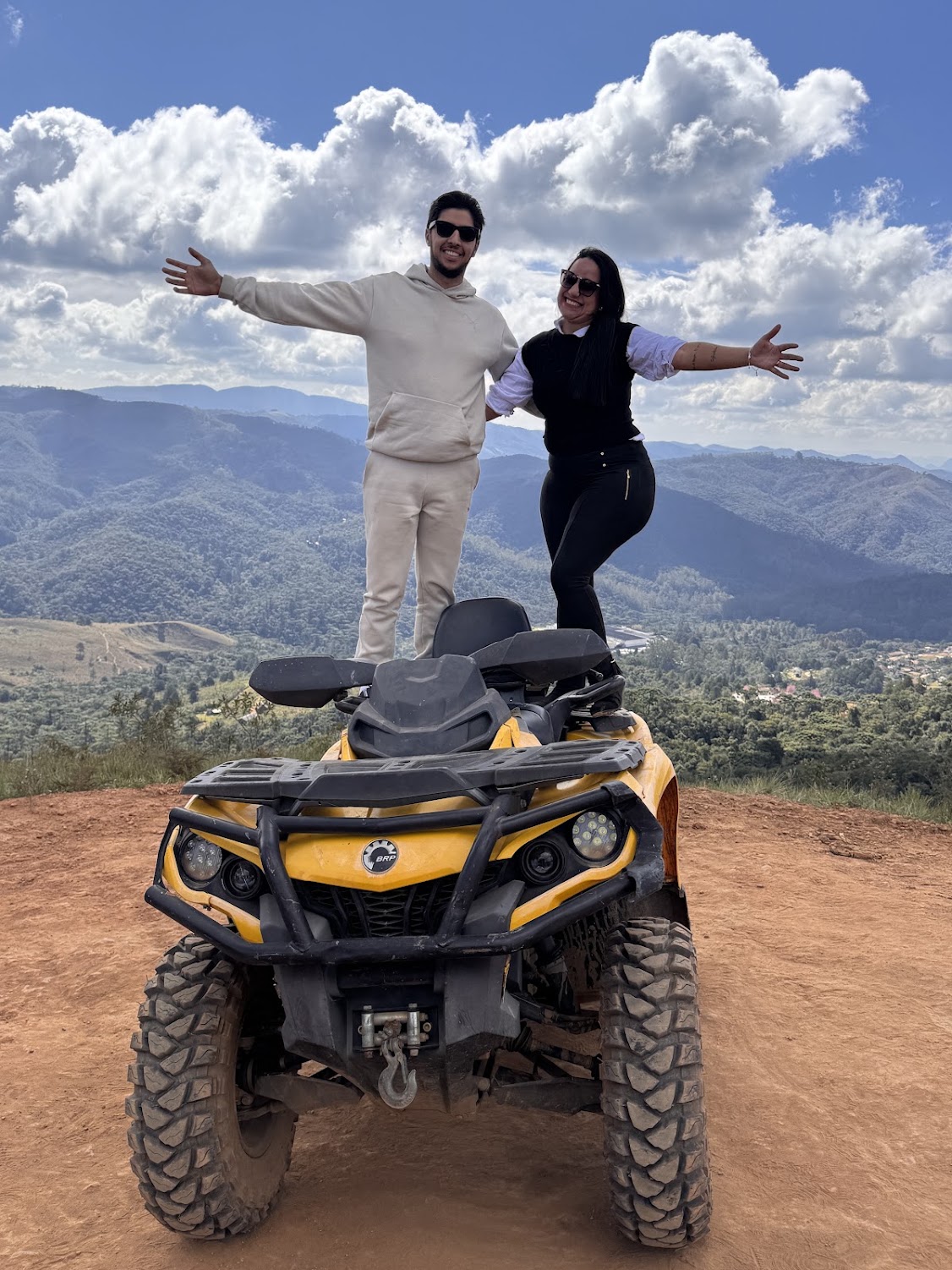 Afonso e Thamires em cima de um quadriciclo com as montanhas ao fundo